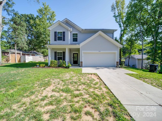 view of front facade featuring an attached garage, a front lawn, fence, covered porch, and driveway