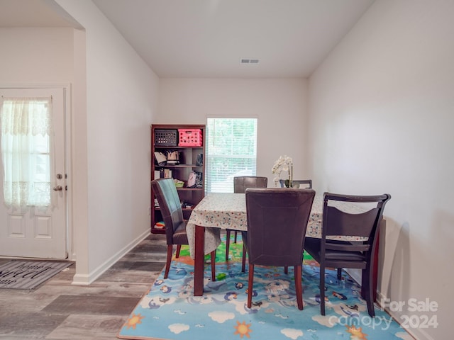 dining area with visible vents, baseboards, and wood finished floors