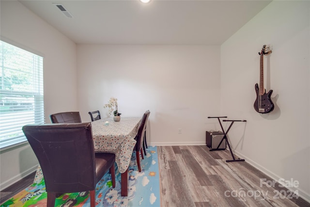 dining room with plenty of natural light, baseboards, visible vents, and wood finished floors