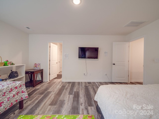 bedroom featuring wood finished floors, visible vents, and baseboards