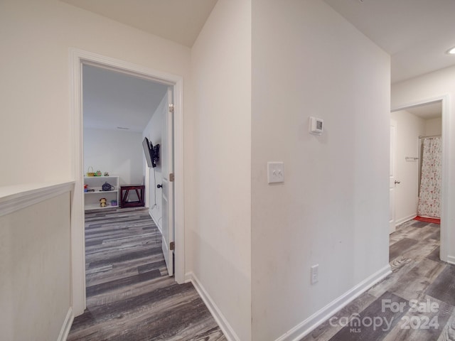 hall with baseboards and wood finished floors