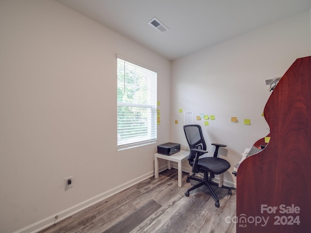 home office featuring wood finished floors, visible vents, and baseboards