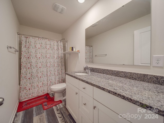 bathroom with vanity, a shower with shower curtain, wood finished floors, visible vents, and toilet