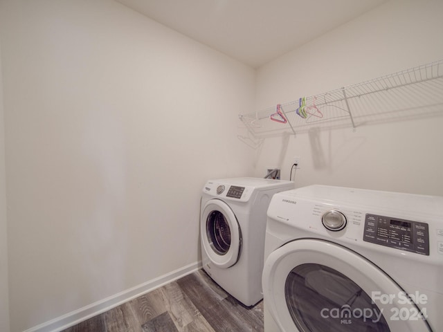 clothes washing area with dark wood finished floors, laundry area, baseboards, and independent washer and dryer