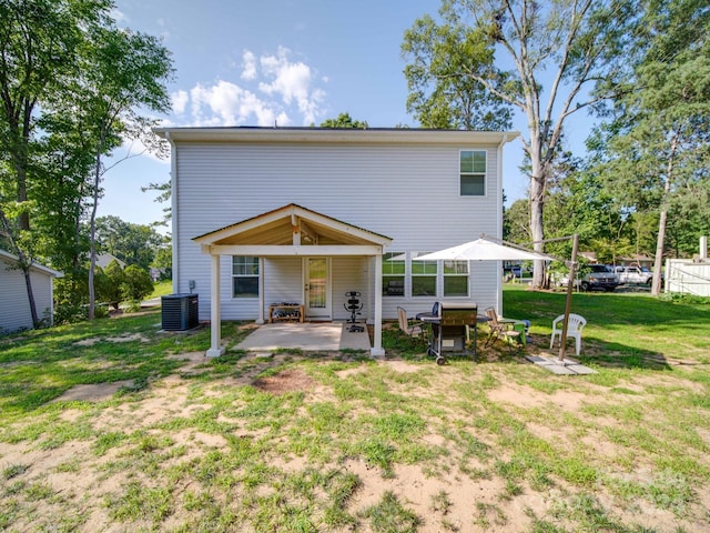 rear view of property with a yard, a patio area, and central AC