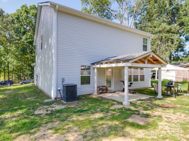 back of house with a patio area, central air condition unit, and a lawn