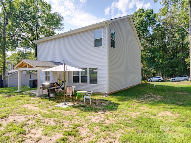 back of property featuring central AC unit, a lawn, and a patio