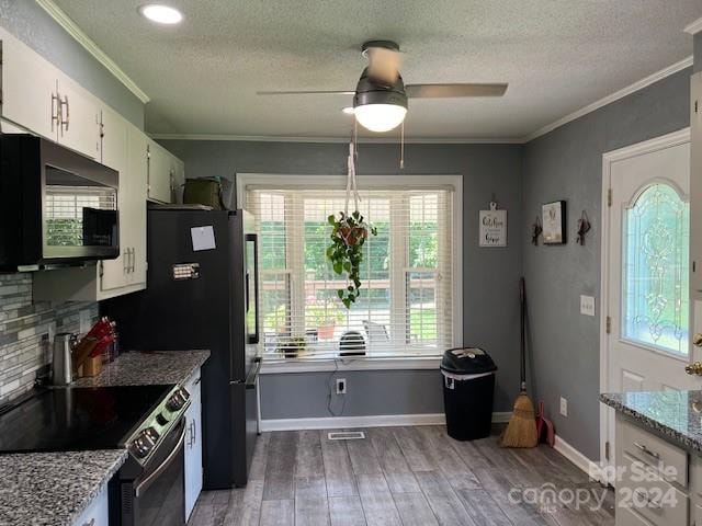 kitchen featuring white cabinetry, light hardwood / wood-style floors, range with electric cooktop, and a wealth of natural light