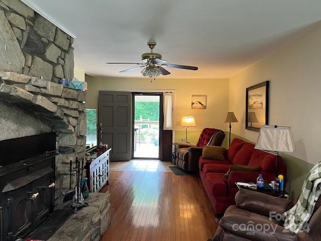 living room with ceiling fan, a fireplace, and hardwood / wood-style flooring