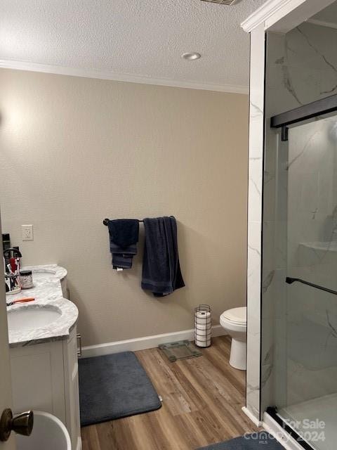 bathroom with walk in shower, a textured ceiling, toilet, vanity, and hardwood / wood-style floors