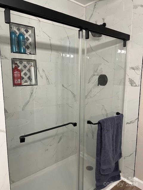 bathroom featuring a shower with door