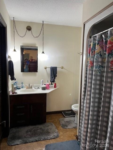 bathroom with vanity, tile patterned floors, a textured ceiling, and toilet