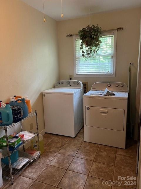 laundry area featuring a notable chandelier, light tile patterned flooring, and washer and clothes dryer