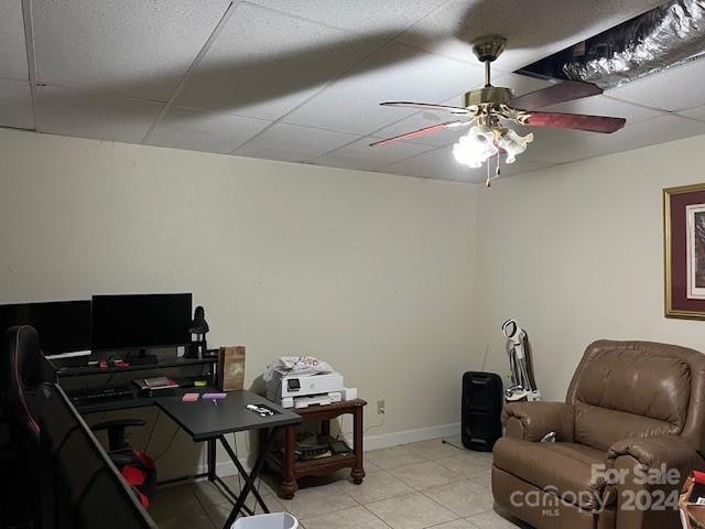 tiled home office featuring ceiling fan and a drop ceiling