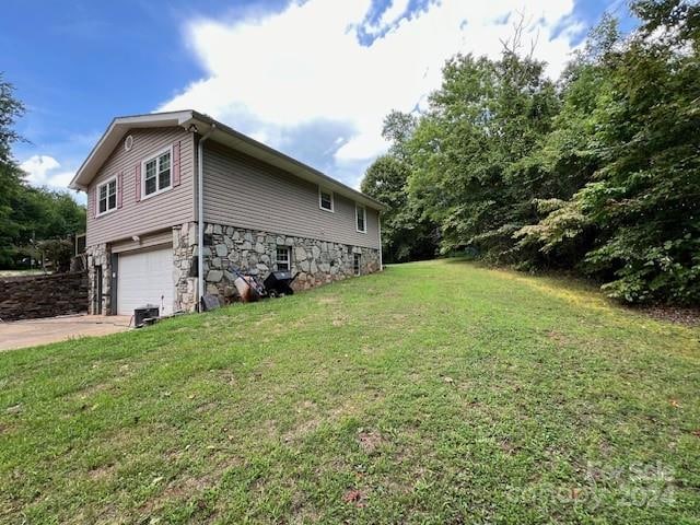 view of side of home with a garage and a lawn