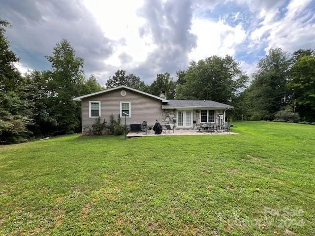 rear view of property with a patio area and a lawn