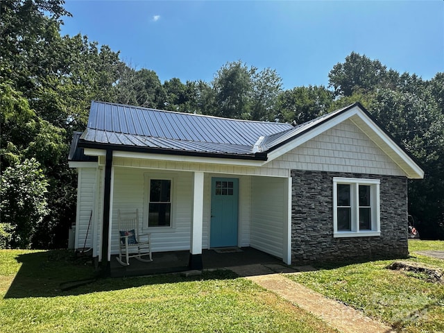 view of front of house with covered porch and a front lawn