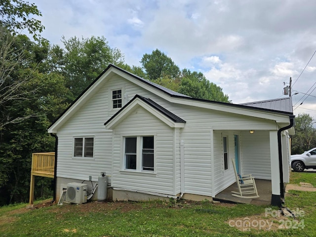 exterior space featuring a front yard and ac unit