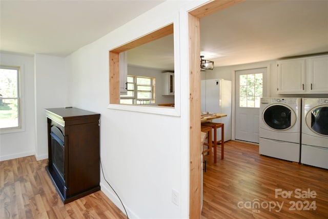 laundry area featuring light hardwood / wood-style flooring, cabinets, and washing machine and clothes dryer