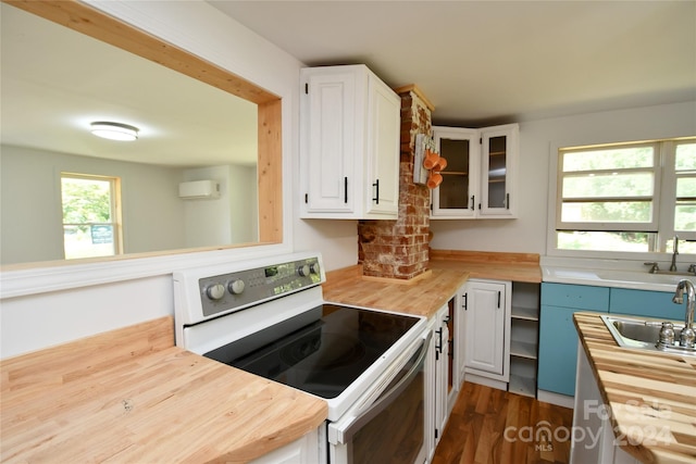 kitchen with butcher block counters, sink, white cabinetry, a wall mounted air conditioner, and white range with electric cooktop