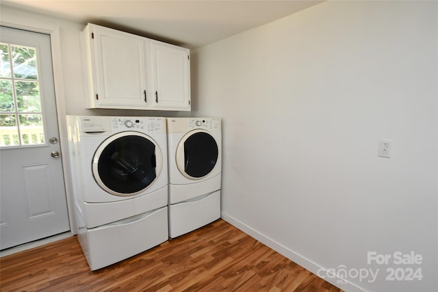 laundry area featuring hardwood / wood-style floors, cabinets, and washing machine and clothes dryer