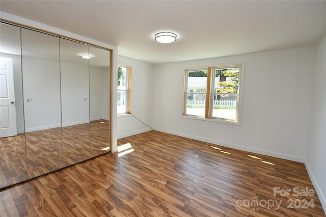 unfurnished bedroom featuring dark hardwood / wood-style floors and a closet