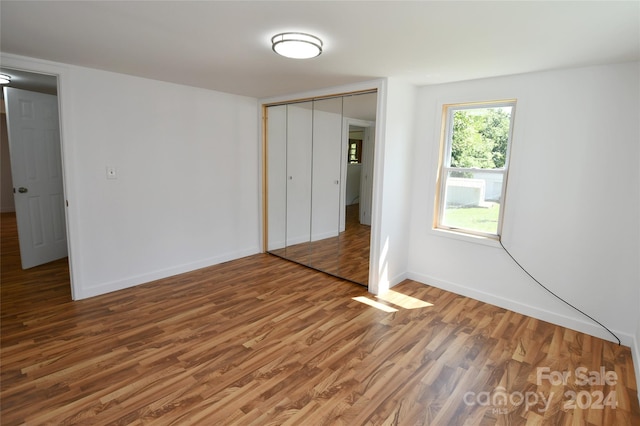 unfurnished bedroom with wood-type flooring and a closet