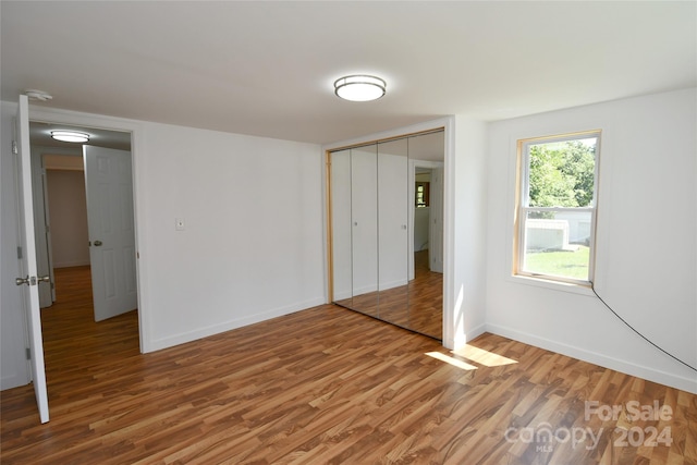 unfurnished bedroom with hardwood / wood-style floors and a closet