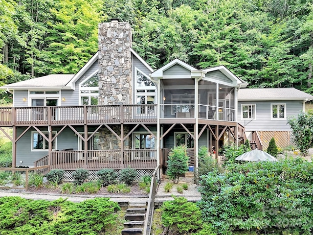 back of property with a sunroom and a deck