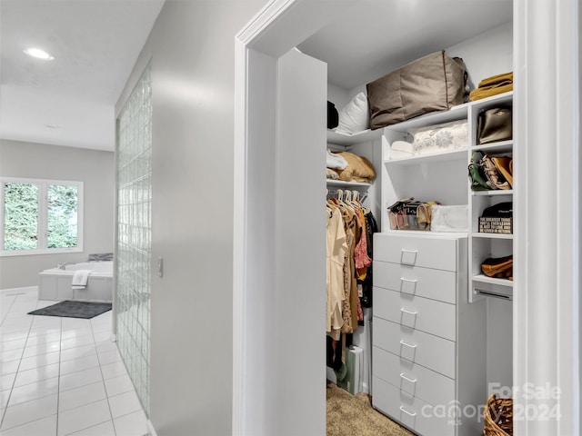 walk in closet featuring light colored carpet