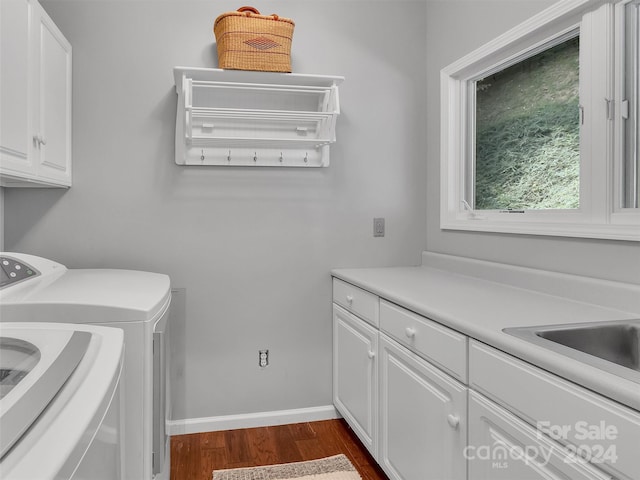 washroom featuring washing machine and clothes dryer, cabinets, and dark hardwood / wood-style floors