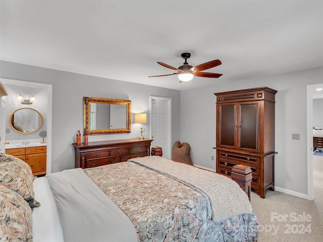 bedroom with light colored carpet, ensuite bath, and ceiling fan