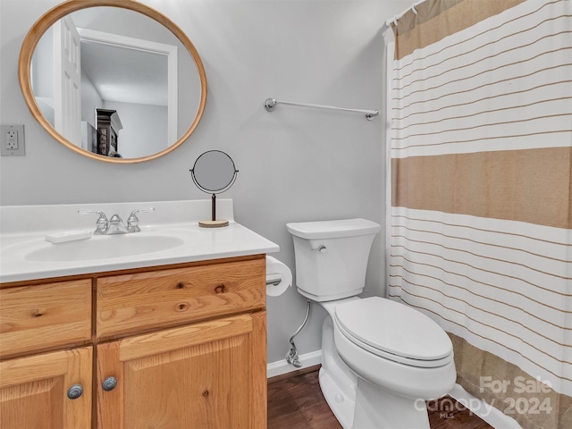 bathroom featuring hardwood / wood-style floors, walk in shower, toilet, and vanity