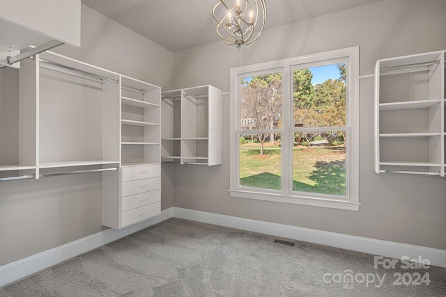 walk in closet featuring carpet floors and a notable chandelier