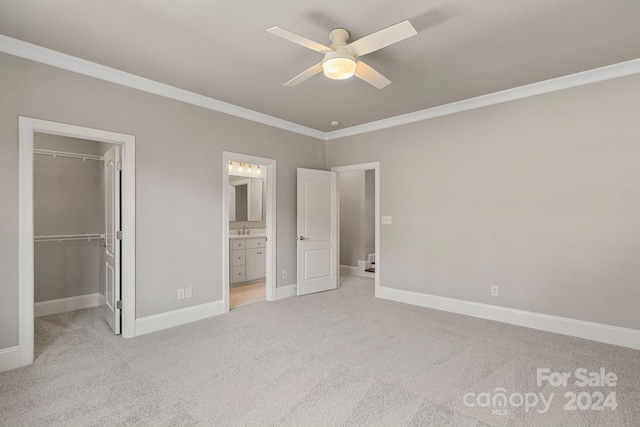 unfurnished bedroom with connected bathroom, a spacious closet, ceiling fan, light carpet, and a closet