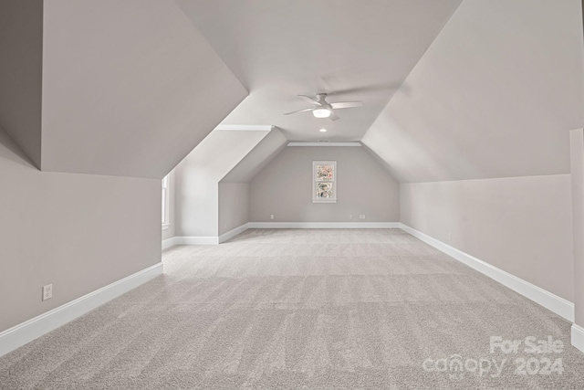 bonus room with ceiling fan, lofted ceiling, and light carpet