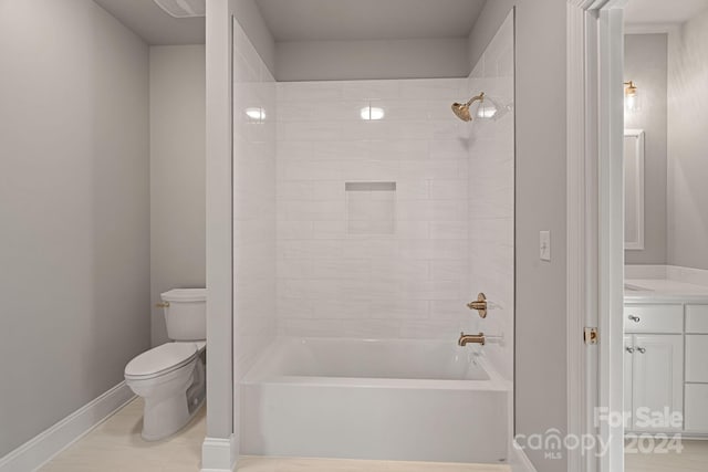 full bathroom with tile patterned floors, vanity, tiled shower / bath combo, and toilet