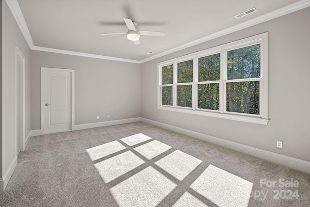 carpeted spare room with crown molding and ceiling fan