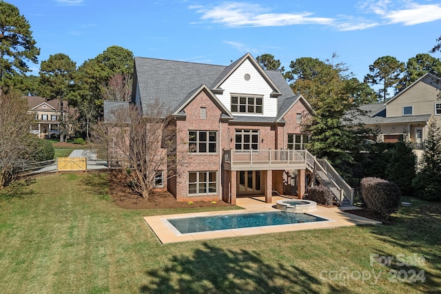 back of house featuring a lawn, an in ground hot tub, and a wooden deck