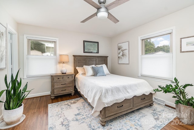 bedroom featuring a ceiling fan, baseboards, visible vents, and wood finished floors