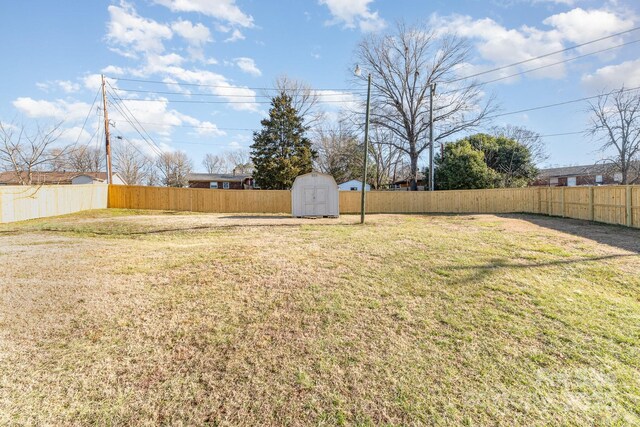 view of yard with a fenced backyard, an outdoor structure, and a shed