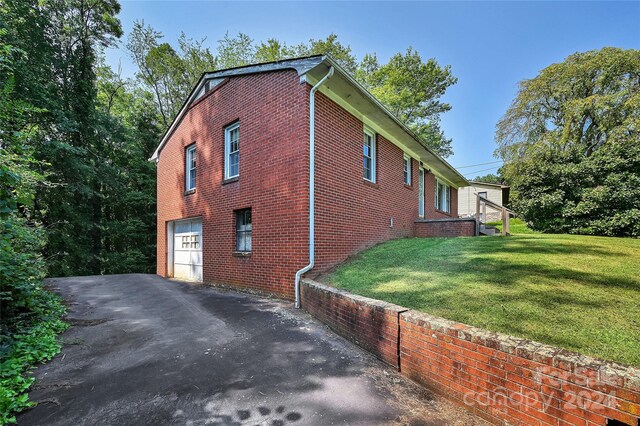 view of side of home with a garage and a yard