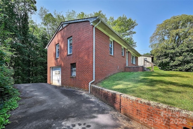 view of side of property featuring a garage and a yard