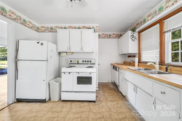 kitchen featuring white appliances, a healthy amount of sunlight, sink, and white cabinets