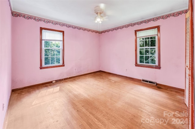 empty room with ceiling fan and light hardwood / wood-style flooring