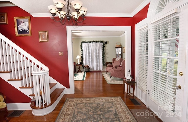 foyer entrance with crown molding, a chandelier, and dark hardwood / wood-style flooring