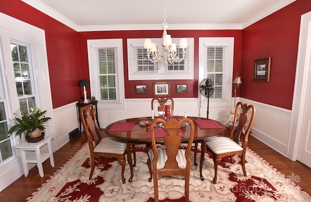 dining area with dark hardwood / wood-style floors, a notable chandelier, and plenty of natural light