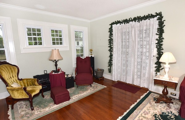 sitting room with crown molding and wood-type flooring