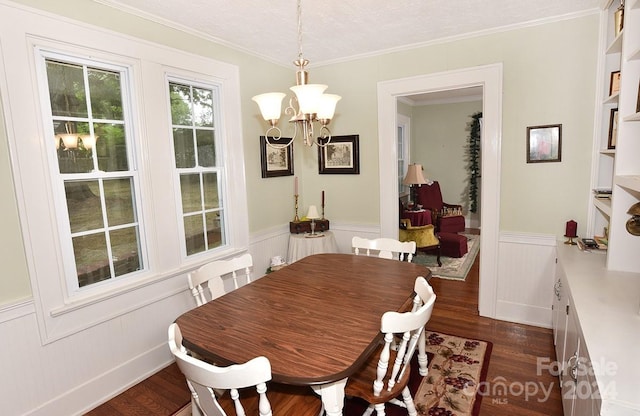 dining space with a textured ceiling, dark hardwood / wood-style flooring, a chandelier, and ornamental molding