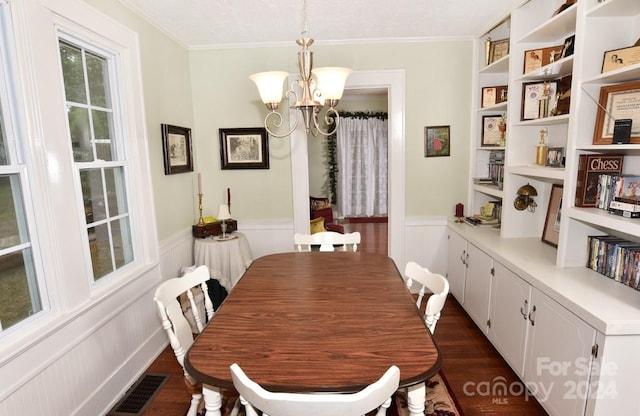 dining space featuring a notable chandelier, ornamental molding, a textured ceiling, and dark hardwood / wood-style floors